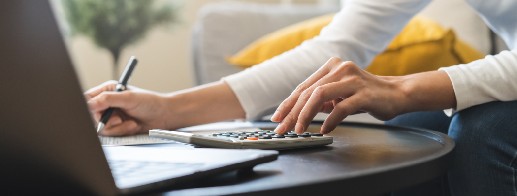 Woman declaring tax using a laptop and a calculator.